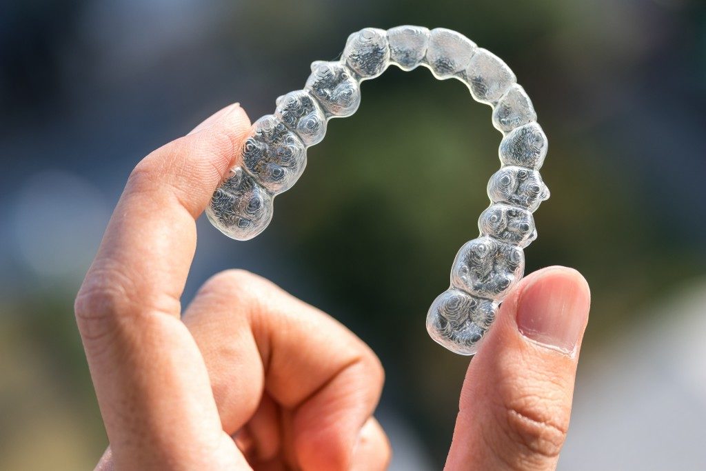 Person holding his invisible aligners