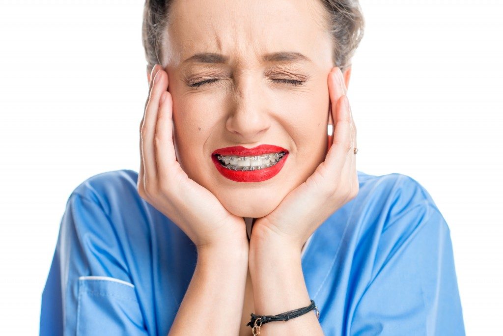 woman in pain wearing braces