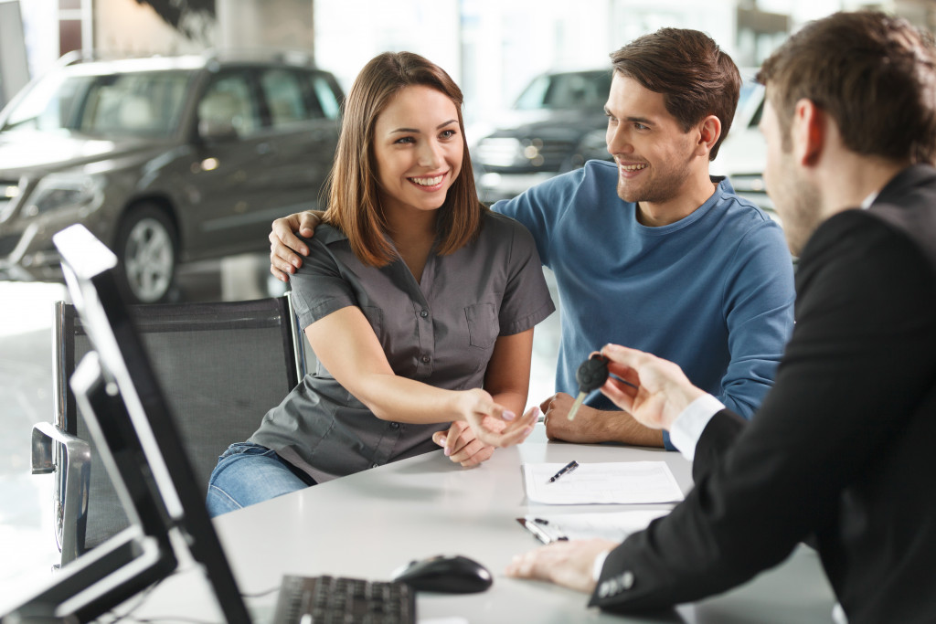 couple receiving a car key in a dealership