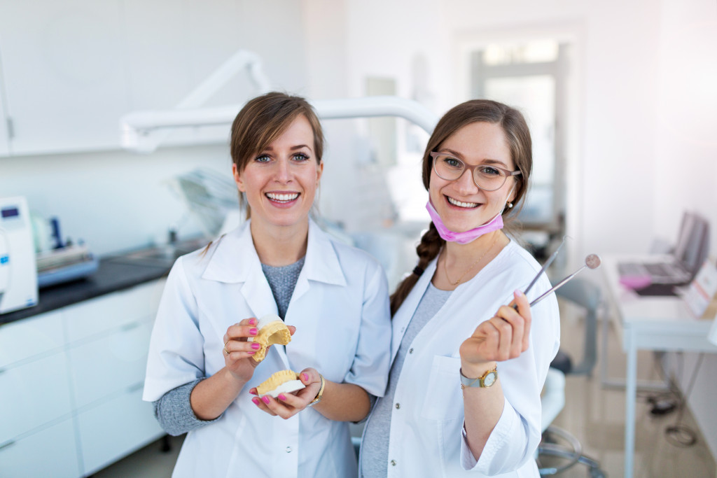 two female dentists holding dental equipment in the room